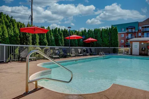 Outdoor swimming pool with loungers and red umbrellas