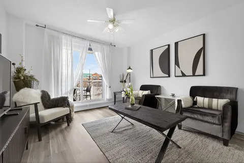 Sitting area with leather chairs, a television and balcony doors