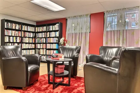 Library with bookshelves, leather armchairs and a small table