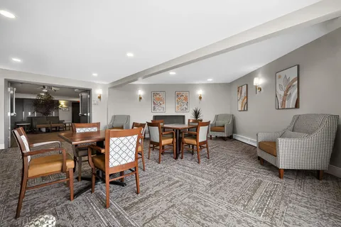 Room with tables, chairs, armchairs and floral artwork