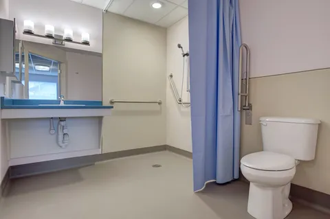 Accessible bathroom with a sink, toilet and shower curtain