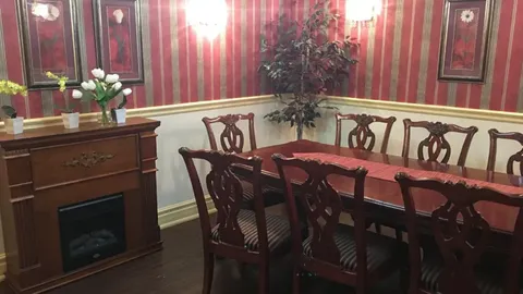 Private dining room with a long wooden table and a fireplace.