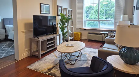 Suite living room with a sofa, television and a large window.