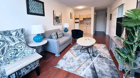 Suite living area with a sofa, television and kitchenette.