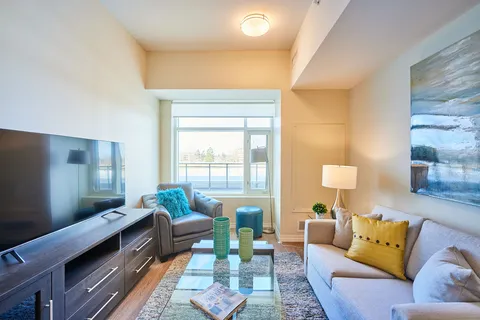 Room with a sofa, an armchair, a television and a glass coffee table