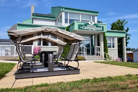 Green and white building with a covered entrance and a canopy swing in front