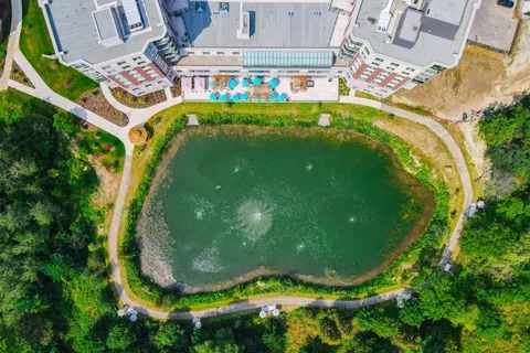 Aerial view of the pond and landscaping beside the residence.