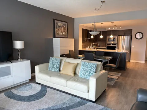 Suite living room with a sofa and open kitchen.
