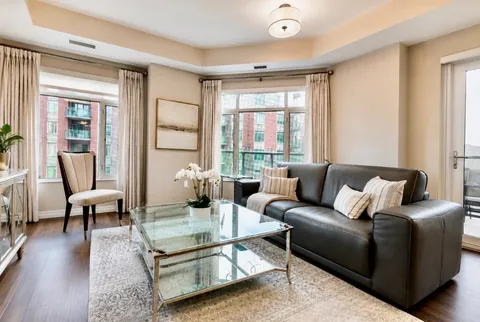 Suite living room with a sofa, coffee table and large windows.