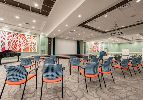 Event room with chairs and tables facing a stage.