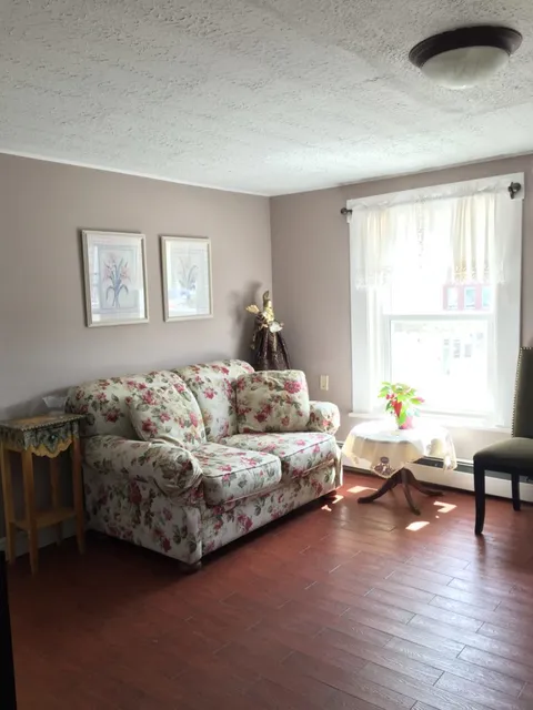 Sitting room with a floral sofa and large windows.