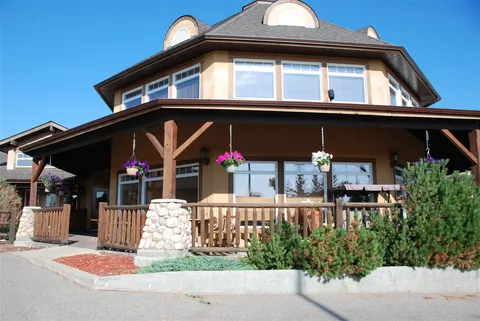 Residence facade with a covered porch and upper-floor windows.