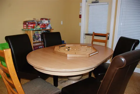 Games area with a round table, chairs and board games.