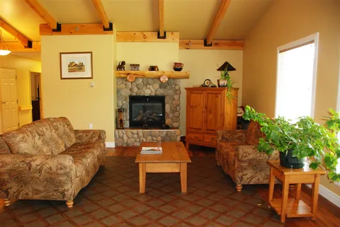 Shared lounge with a sofa, fireplace, cabinets and potted plants.