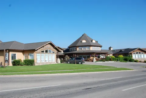Residence buildings with a broad front lawn and a driveway.
