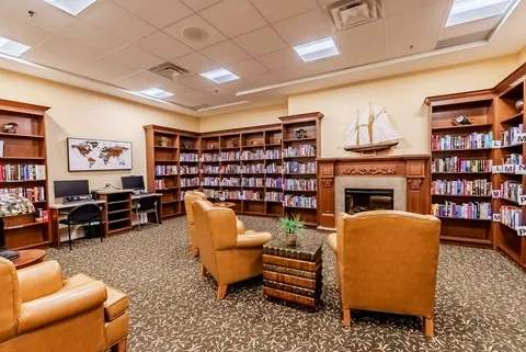 Armchairs and bookshelves around a fireplace
