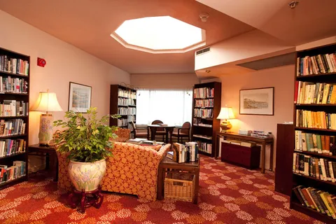 Library with bookshelves, upholstered seating and a skylight