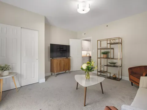 Room with a sofa, television, open shelving and a coffee table