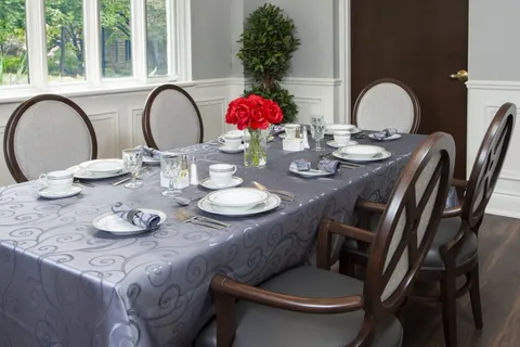 Private dining room with a set table and upholstered chairs.