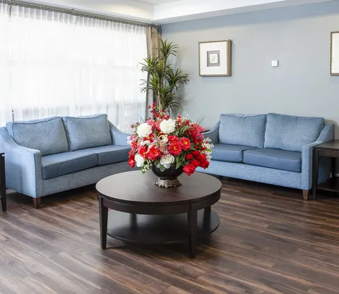Lounge with two sofas, side tables and a central flower arrangement.