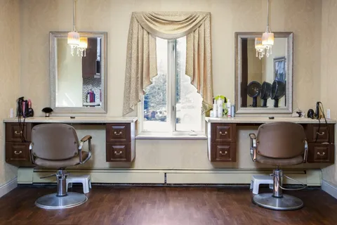 Hair salon with two styling chairs, mirrors and counters.