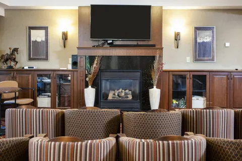 Lounge with upholstered seating, a fireplace and television.