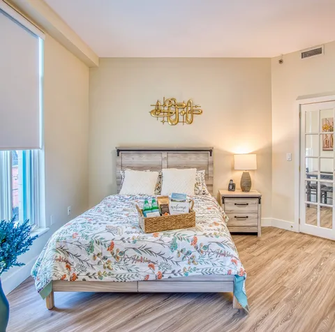 Bedroom with a double bed, bedside tables and glass-panelled doors.
