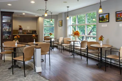 Bistro with tables, chairs, a counter and large windows.