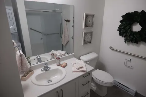 Bathroom with a sink, vanity, toilet and shower.