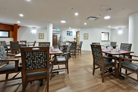 Dining room with tables, wooden chairs and ceiling lights.