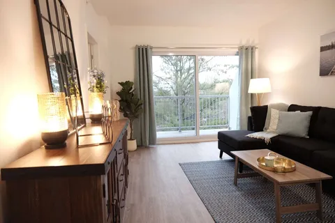 Suite living room with a sofa beside a patio door.
