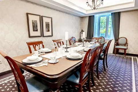 Long dining table set with white plates, glasses and candles