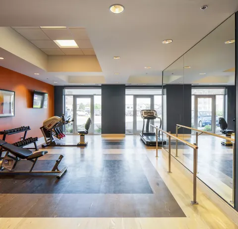 Fitness room with exercise equipment, handrails and glazed doors.