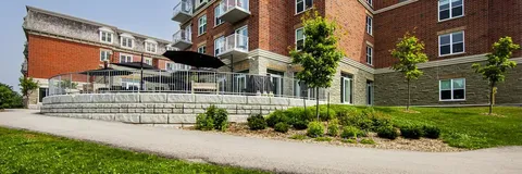 Path and landscaped garden beside the brick exterior and outdoor terrace.