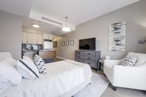Studio suite with a bed, armchair, television and kitchen.