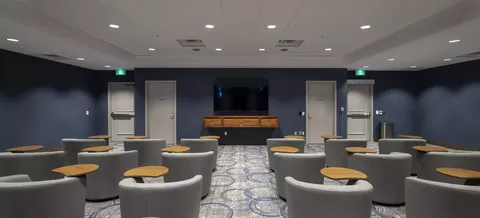 Theatre room with rows of chairs and a screen at the front.