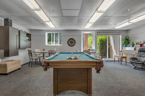 Room with a pool table and pale walls