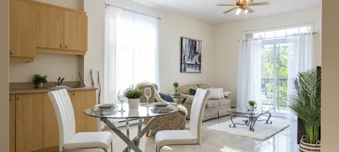 Apartment dining and living area with a kitchenette and patio door.