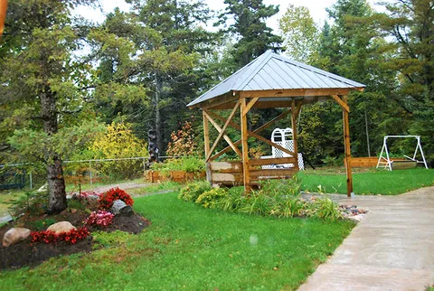 Garden with a timber gazebo, flowers and a paved path