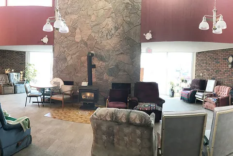 Room with armchairs around a stone fireplace
