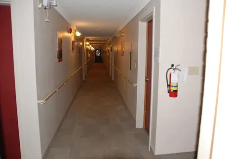 Carpeted hallway with handrails and doors