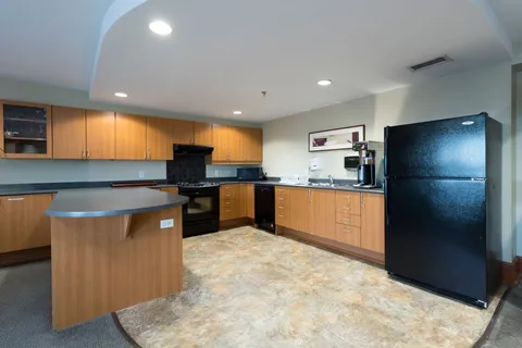 Kitchen with wooden cabinets, black appliances and a peninsula counter