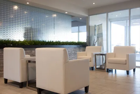 Room with four armchairs, a round table and textured grey walls