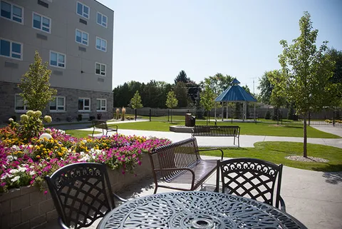 Patio with a metal table, benches and flower beds