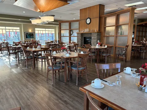 Concordia Village I dining room with tables, wooden chairs and large windows.