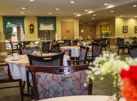 Dining room with set tables, patterned chairs and green window valances