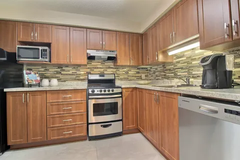 Kitchen with wooden cupboards, a stove, microwave and dishwasher