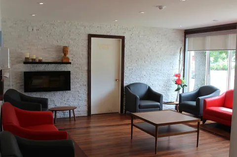 Lounge with red and black seating around a stone fireplace.