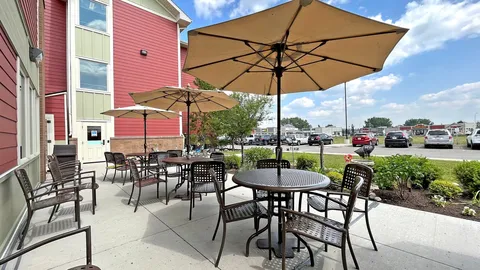 Patio with tables, chairs and umbrellas beside the building