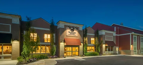 Low-rise building with a lit central entrance at dusk